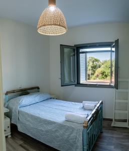 ein Schlafzimmer mit einem Bett und einem Fenster in der Unterkunft Olive Coast Houses in Kyparissia