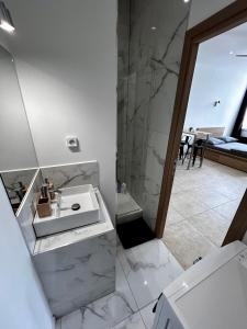 a white bathroom with a sink and a shower at Appartement vue imprenable Vieux-Port et Notre Dame in Marseille
