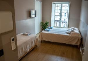 a bedroom with two beds and a window at Top Rooms Torino in Turin
