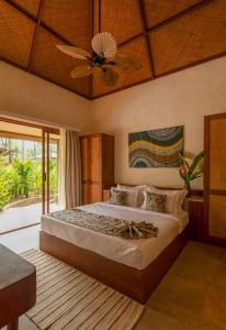 sypialnia z łóżkiem i wentylatorem sufitowym w obiekcie Anemos Boutique Living and Spa w mieście Morjim