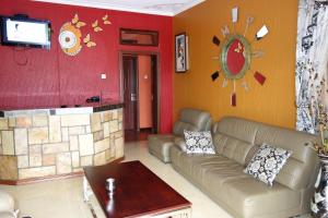 a living room with a couch and a tv at Impala Suites in Jinja