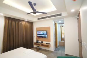 a bedroom with a ceiling fan and a television at Royal Raven Hotel & Banquet' Greater Noida Nearby India Expo Centre & Mart in Greater Noida