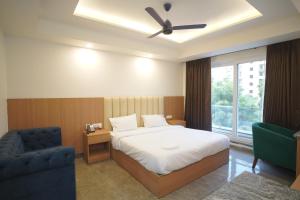 a bedroom with a bed and a chair and a window at Royal Raven Hotel & Banquet' Greater Noida Nearby India Expo Centre & Mart in Greater Noida