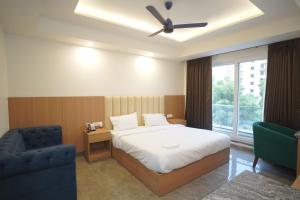 a bedroom with a bed and a chair and a window at Royal Raven Hotel & Banquet' Greater Noida in Greater Noida +208 photos
