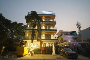 a building with a car parked in front of it at Royal Raven Hotel & Banquet' Greater Noida in Greater Noida