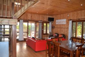 a living room with a table and a red couch at Onda Azul Main House in Ponta do Ouro