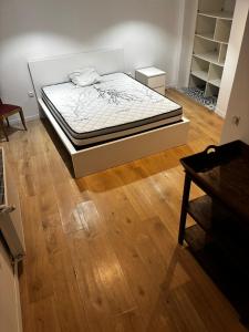 a bed in a room with a wooden floor at Appartement Victoire in Bordeaux