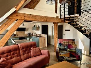 a living room with a couch and a chair at La Faran'dole - Confortable duplex in Dole
