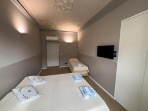 a small room with two beds and a flat screen tv at Top Rooms Torino in Turin