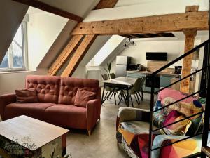 a living room with a couch and a table at La Faran'dole - Confortable duplex in Dole
