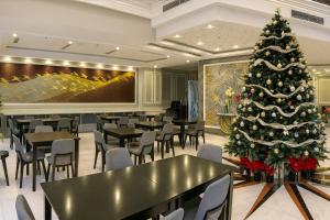 un sapin de Noël dans un restaurant avec des tables et des chaises dans l'établissement Tuong Vi Corner Hotel, à Hô-Chi-Minh-Ville