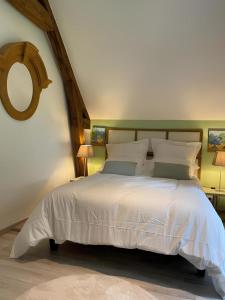 a bedroom with a white bed and a mirror at La Chênaie - Suites individuelles dans un domaine d'art contemporain et nature in Gien +49 photos