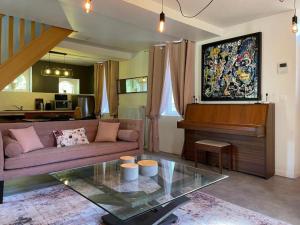 a living room with a couch and a piano at La Chênaie - Suites individuelles dans un domaine d'art contemporain et nature in Gien