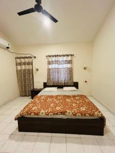 a bedroom with a bed and a ceiling fan at The golden villa in Calangute