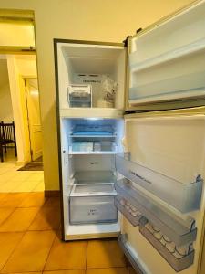 an empty refrigerator with its door open in a kitchen at The golden villa in Calangute