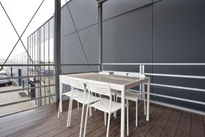 a white table and chairs on a balcony at Stilvolle Apartments I home2share in Dessau