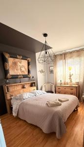 Un dormitorio con una cama grande y una lámpara de araña. en Villa du Siéck bord de mer piscine 14 P, en Santec