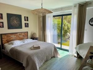 Un dormitorio con una cama grande y una ventana grande en Villa du Siéck bord de mer piscine 14 P, en Santec