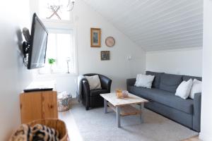 a living room with a blue couch and a table at Toftenäs gästhus in Toftenäs