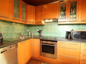 eine Küche mit Holzschränken und Geräten aus Edelstahl in der Unterkunft Chalet 5 ch, 11 pers, terrasse sud, Les Carroz - FR-1-572-115 in Arâches-la-Frasse + 6 Fotos