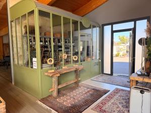 Un armario verde lleno de botellas de vino. en Villa du Siéck bord de mer piscine 14 P, en Santec