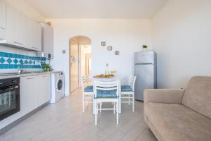 a kitchen and a living room with a couch and a table at AffittaSardegna-Casa Pesca in Cascabraga