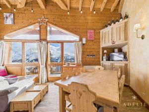 een eetkamer met een tafel en een groot raam bij Chalet 4 pièces centre station, parking inclus - FR-1-398-591 in La Rosière