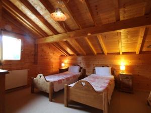 ein Schlafzimmer mit zwei Betten in einer Blockhütte in der Unterkunft Chalet typique 10 pers, Arâches-la-Frasse - FR-1-572-27 in Arâches-la-Frasse