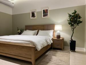 a bedroom with a large bed and a potted plant at بوتيك هاوس بدخول ذاتي وصالة أنيقة in Hail
