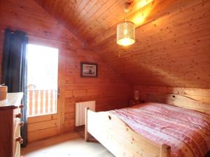 ein Schlafzimmer mit einem Bett in einer Holzhütte in der Unterkunft Chalet équipé avec poêle et garage, proche centre et remontées mécaniques - FR-1-572-107 in Les Carroz d'Araches