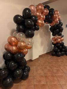 a column of black and brown balloons next to a doorway at Dom przy Rezerwacie in Trzciel
