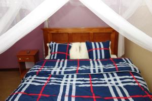 a bedroom with a bed with blue and red stripes at Impala Suites in Jinja