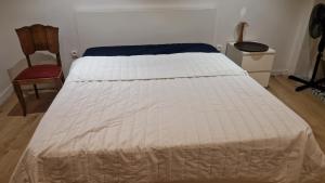 a white bed in a room with a chair at Appartement Victoire in Bordeaux