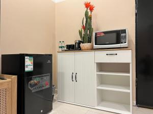 a kitchen with a microwave and a refrigerator at بوتيك هاوس بدخول ذاتي وصالة أنيقة in Hail