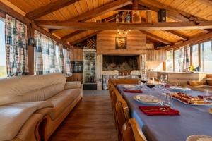 a dining room with a long table and couches at Stone villa Jurenda with pool in Debeljak