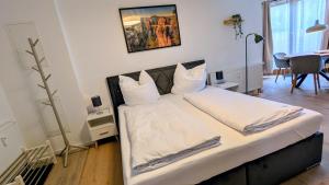 ein Schlafzimmer mit einem großen Bett mit weißen Laken und Kissen in der Unterkunft CASA BENJI Dohma - geräumige FeWo - Familien - Parkplatz - Waschmaschine in Dohma