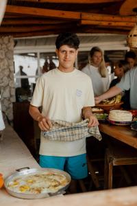 a man standing in a kitchen with a pan of food at Surf HouseMaroc in Essaouira