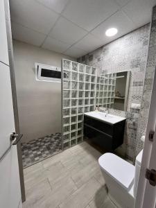 a bathroom with a toilet and a sink at Casa moderna en Manises con 2 terrazas in Manises +16 photos
