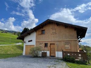 un grand bâtiment en bois avec un garage dans l'établissement Chalet chaleureux 8 pers, 5 ch, cheminée, proche pistes, Crest-Voland - FR-1-733-5, à Crest-Voland