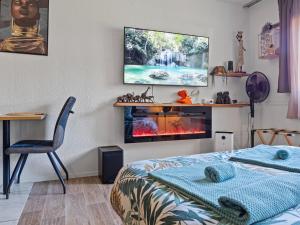 a bedroom with a bed and a tv on the wall at Romance&Tentation-Balnéo 2 places in Carquefou