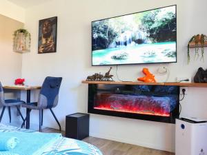 a living room with a tv and a fire place at Romance&Tentation-Balnéo 2 places in Carquefou