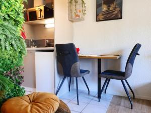 a small kitchen with a table and two chairs at Romance&Tentation-Balnéo 2 places in Carquefou