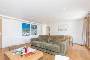una sala de estar con un sofá y una mesa en Appartements dans le Chalet Nessa - Combloux, en Combloux