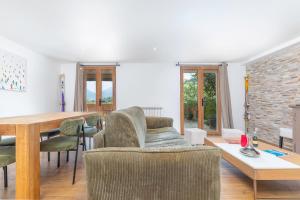 Una sala de estar con un sofá y sillas y una mesa. en Appartements dans le Chalet Nessa - Combloux, en Combloux