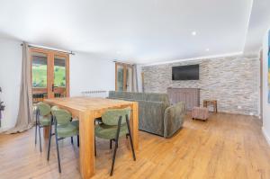 Una sala de estar con una mesa de madera y un sofá. en Appartements dans le Chalet Nessa - Combloux, en Combloux