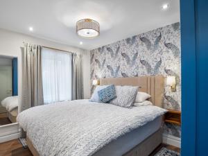 a bedroom with a bed and a wall with wallpaper at 2 Harbour View in Roundstone
