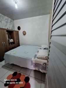 a small bedroom with a bed and a rug at Casa de Praia in Mosqueiro