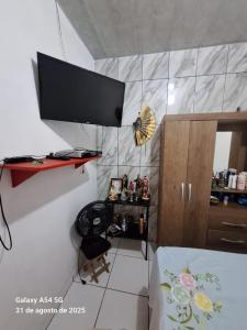 a room with a desk and a television on a wall at Casa de Praia in Mosqueiro
