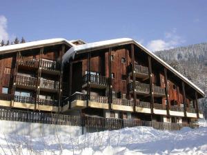 ein großes Gebäude im Schnee mit Schnee auf dem Boden in der Unterkunft Spacieux 2 Pièces aux Carroz, 6 Pers., Balcon ensoleillé - FR-1-572-9 in Arâches-la-Frasse