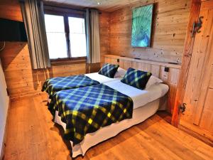 ein Schlafzimmer mit einem Bett in einer Blockhütte in der Unterkunft Charmant 3 pièces rénové avec sauna et jacuzzi pour 6 pers. au Grand-Bornand - FR-1-458-107 in Le Grand-Bornand